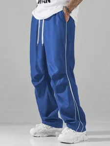 Lockere blaue Herren-Techwear-Hose mit weißen Seitenstreifen, urbaner Streetwear-Stil