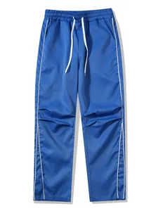 Detailansicht der blauen Retro Techwear Sporthose mit weißen Seitenstreifen und Kordelzug.