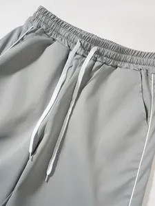 Nahaufnahme einer grauen Herren-Funktionshose mit weißem Kordelzug und Paspeln