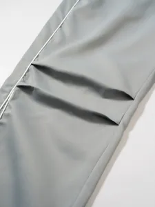 Nahaufnahme einer grauen Techwear-Hose mit Fokus auf Stofftextur und Taschenfalten