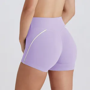 Vista detallada de pantalones cortos de yoga morados de cintura alta con vivos en verde lima.