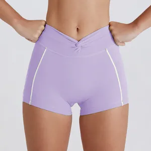 Detalle de los pantalones cortos de yoga lila de cintura alta con cruce y ribete en contraste.