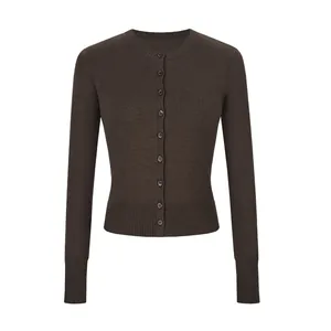 Detailopname van een donkerbruin nauwsluitend kort gebreid vest met knoopsluiting