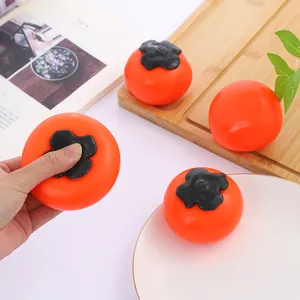 Gros plan montrant l'action de presser un jouet anti-stress en forme de kaki à rebond lent