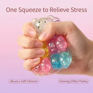 Macro view of hand squeezing colorful glittery transparent jelly bear stress relief toy