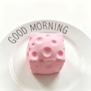 Jouet squishy en forme de fromage rose cerisier pour soulager le stress sur une assiette