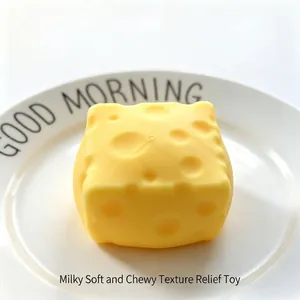 Jouet squishy en forme de fromage jaune pour soulager le stress sur une assiette blanche