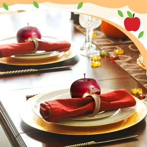 Detalle de un elegante servilletero dorado con forma de manzana en una mesa decorada con estilo
