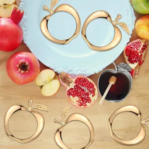 Vista detallada de servilleteros creativos dorados con forma de manzana para mesa elegante