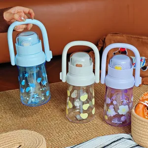 Close-up detail of three portable water bottles featuring straws, handles, and fruit patterns