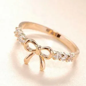 Elegant rose gold bow ring with sparkling crystal accents, close-up macro detail view