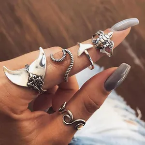 Close-up detail of bohemian style silver ocean themed rings featuring whale tail and turtle