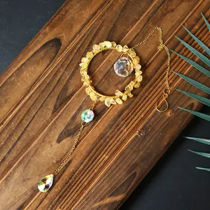 Detailed view of handmade yellow crystal suncatcher featuring iridescent teardrop pendant