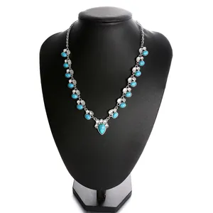 Bohemian floral necklace with turquoise and white stones on black jewelry bust display