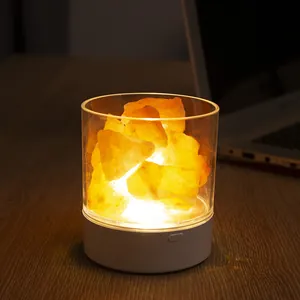Detailed close-up view of a warm Himalayan salt lamp glowing softly on a wooden work desk