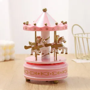 Detailed macro view of pink carousel music box with golden horses and striped top