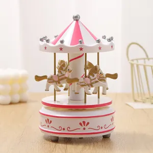 Beautiful detailed shot of a classic pink and white carousel music box with golden horses