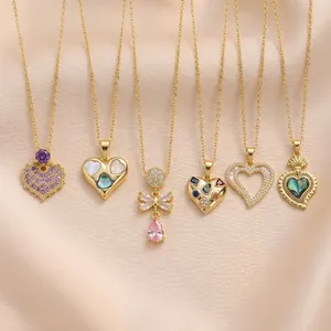 Variety of gold-tone zircon heart and butterfly necklaces on soft pink silk background