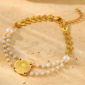Detailed view of an 18K gold-plated bracelet with white pearls and a religious medal.