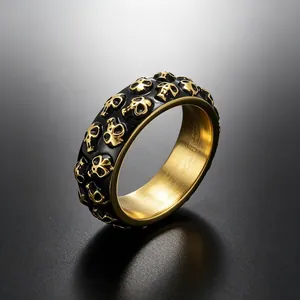 Macro-opname van punk doodskopring voor heren met gouden reliëfschedels op titaniumstaal