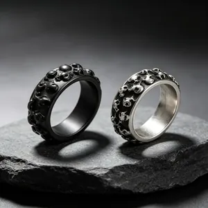 Close-up van het reliëf schedelpatroon op zwarte en zilveren punkstijl titanium ringen