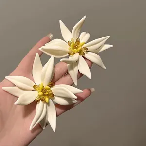 Primer plano detallado que muestra los pétalos de resina de estos pendientes de flores blancas