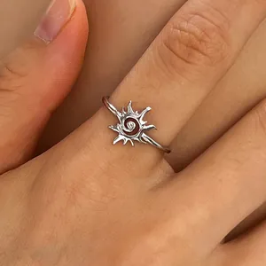 High-definition close-up of a vintage silver sun vortex ring on a woman's finger