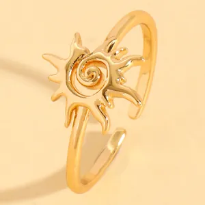 Close-up of golden sun-shaped adjustable ring with spiral vortex detail