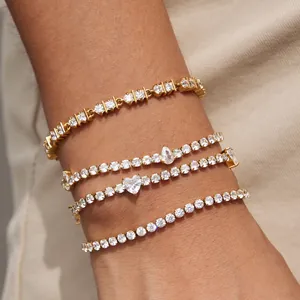 Detailed close-up of four stacked tennis bracelets with heart and pear cubic zirconia stones.