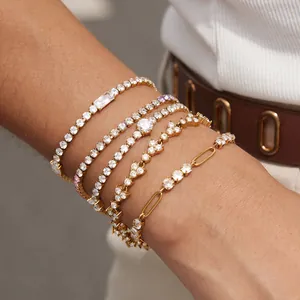 Close-up of stacked 18k gold plated stainless steel tennis bracelets on wrist