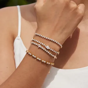 Close-up detail of layered gold-plated tennis bracelets with cubic zirconia accents