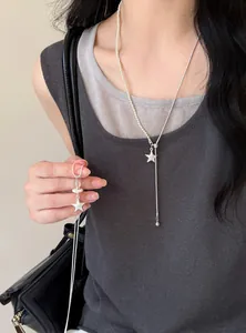 Primer plano de un collar con colgante de estrella minimalista con perlas y cadena