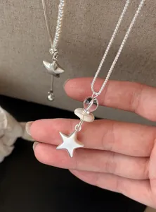 Primer plano detallado de un collar con colgante de estrella de plata y cuentas