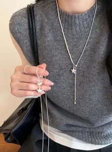 Vista detallada de un collar con colgante de estrella minimalista y elegantes perlas