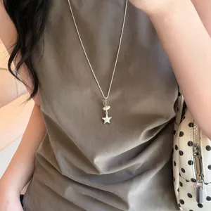 Vista detallada de un collar con colgante de estrella de plata minimalista usado por una modelo