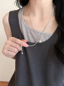 Vista detallada de un collar con colgante de estrella con perlas y cadena de plata