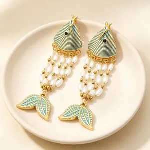 Detailed view of exotic enamel fish tassel earrings with pearls and gold-plated finish.
