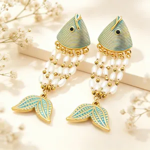 Close-up of exotic enamel fish earrings featuring pearl tassels and gold-plated titanium steel.