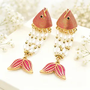Detailed macro shot of exotic fish-shaped red enamel earrings with elegant pearl fringe