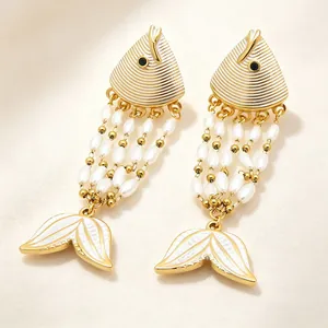 Close-up of enamel fish tassel earrings with pearls and gold plating details.