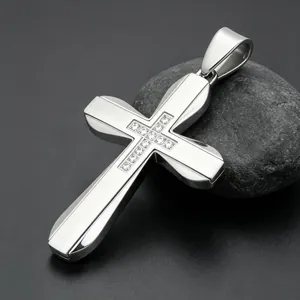 Detail view of a polished stainless steel cross pendant featuring inlaid rhinestones