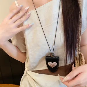 Detail einer Leder-Herz-Halskette, die als funktionaler Brillenhalter dient.