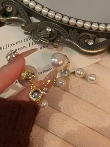 Detailansicht französischer doppelseitiger Perlenohrringe mit eleganten Goldfassungen