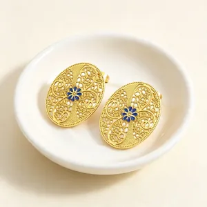 Detailansicht der goldenen filigranen Oval-Ohrstecker mit blauer Emailleblume