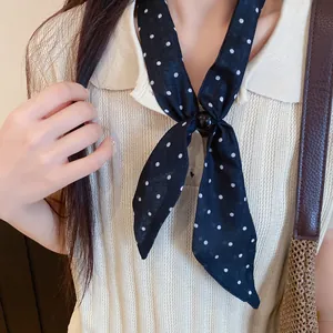 Elegante pañuelo estrecho negro con lunares y botón decorativo en top de punto