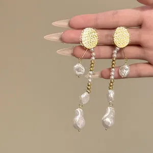 Gros plan de boucles d'oreilles pendantes en perles baroques vintage avec puces