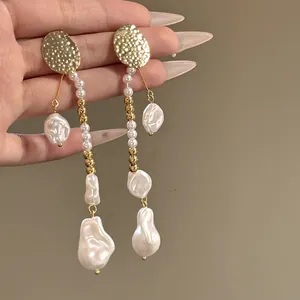 Gros plan de boucles d'oreilles vintage françaises avec perles baroques et perles dorées