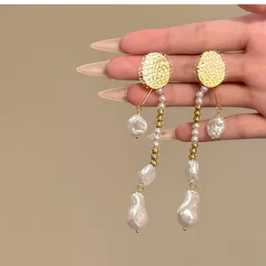 Vue détaillée des boucles d'oreilles en perles baroques vintage avec accents dorés.