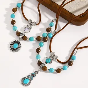 Vista dettagliata di set collane boho con perline turchesi e pendenti in argento antico