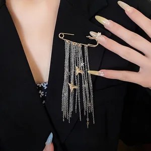 Elegant gold bird and star fringe chain brooch pinned on a stylish black blazer jacket